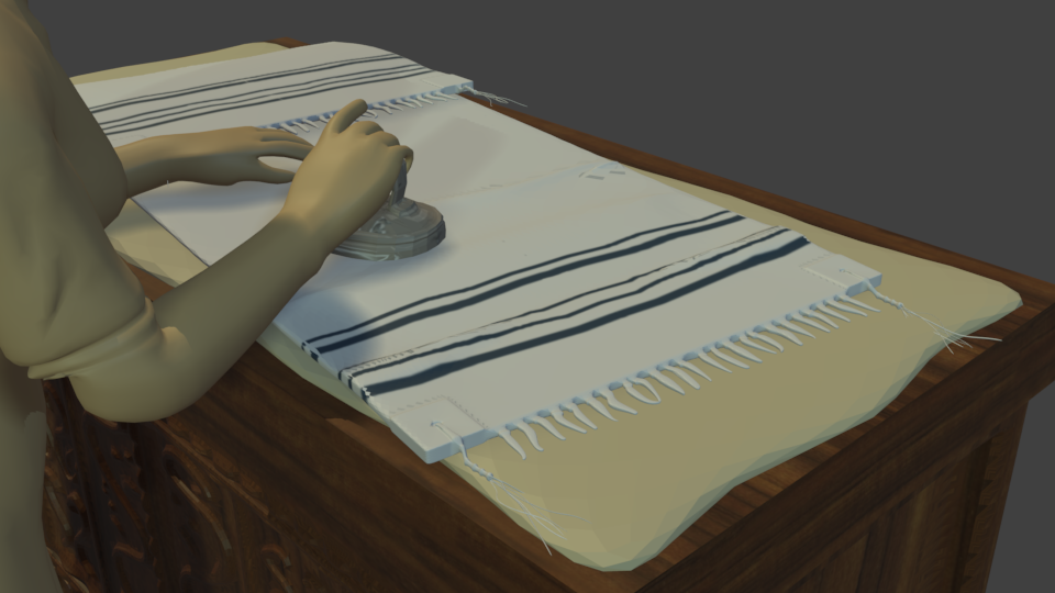 A close up shot of the tallit on the wooden chest. Its detailed fringes and design can be seen. 